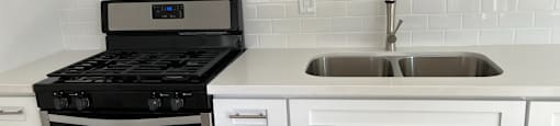 A modern kitchen with a stove and sink.